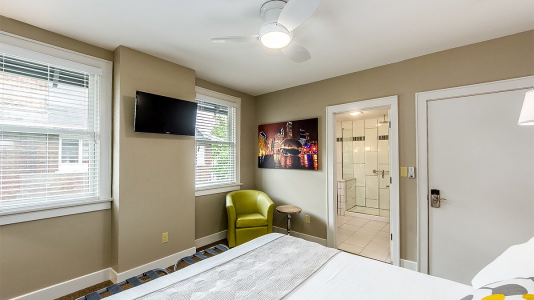 Looking across a bedroom with view of multi-colored canvas wrapped photo of city for which the room was named