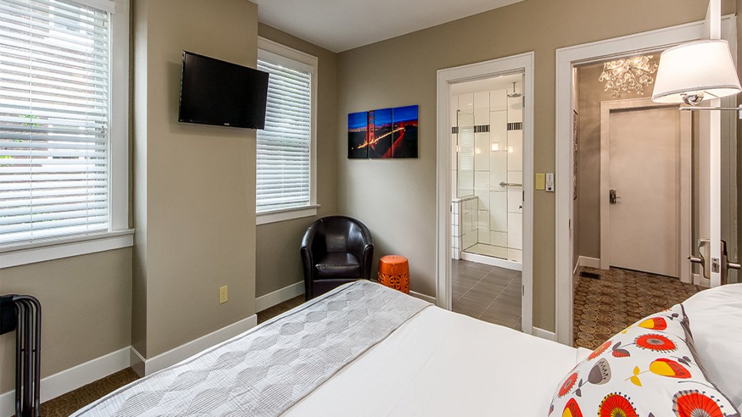 Looking across a bedroom with view of colorful canvas wrapped photo of city for which the room was named