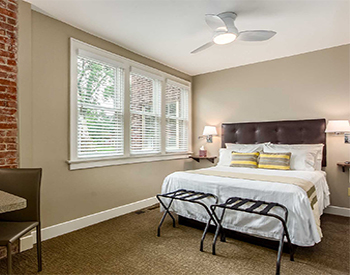 Bed with windows on the left and luggage racks at the foot of the bed.