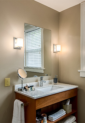 Open shelf hardwood bathroom vanity with pale gray, quartz countertop in Room One