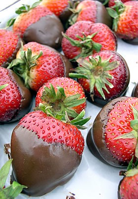Beautiful red strawberries covered in chocolate and laid out upon a plate